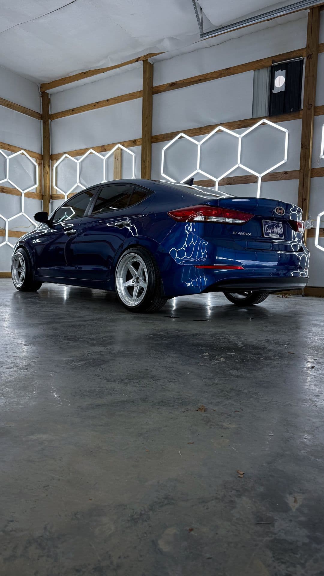 A dark sedan under the hex lighting in the Eagle Pressure bay, the cover shot from the previous site