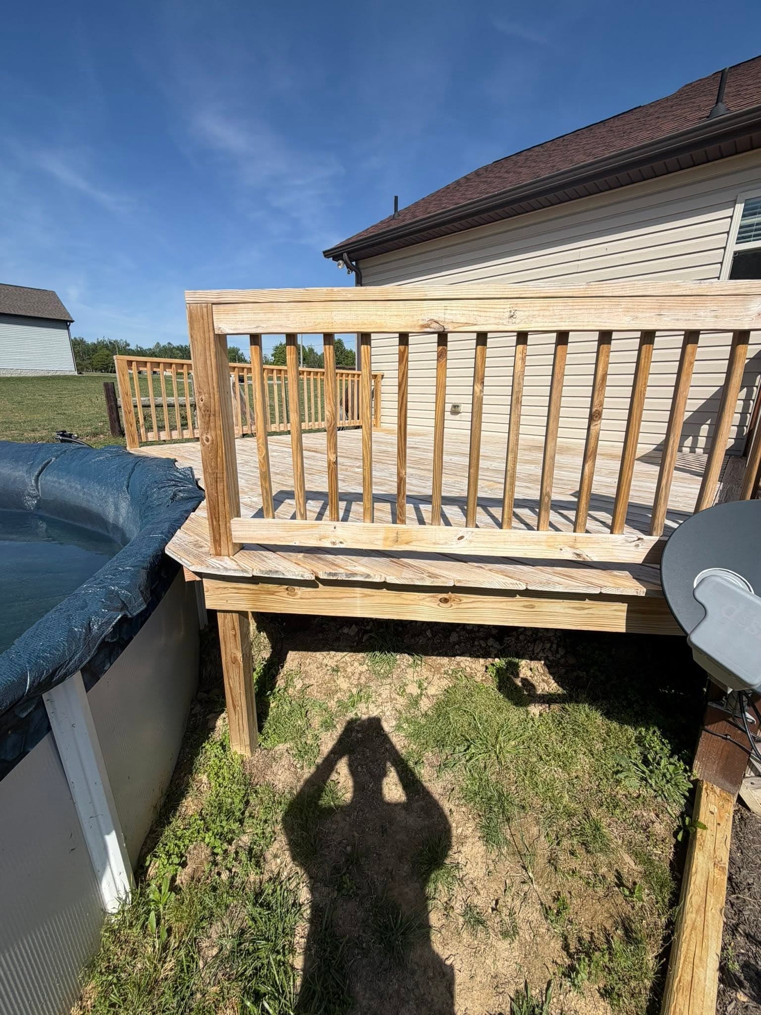 A bare, freshly washed wooden deck and railing before deck staining