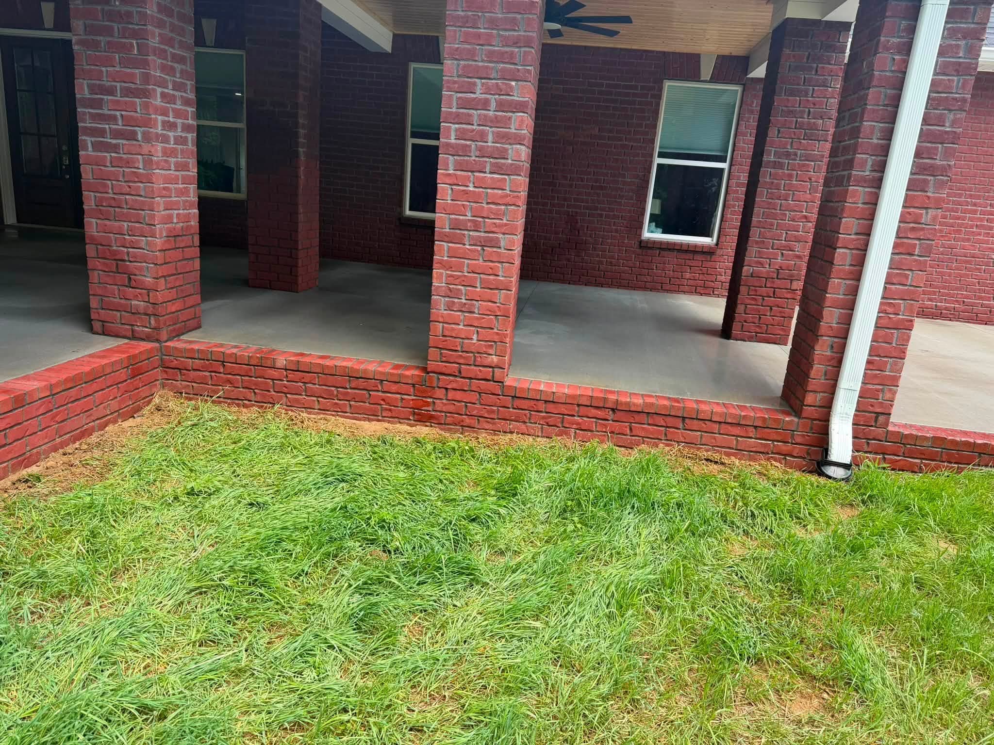The same brick knee wall and pillars after the house wash