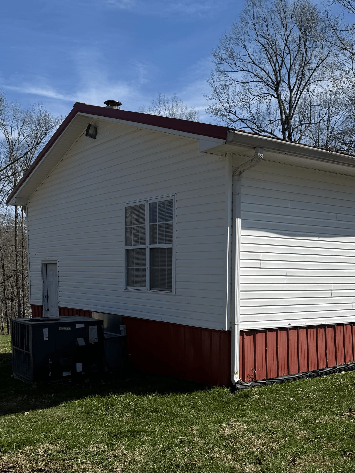 A white house exterior with red skirting after an exterior wash