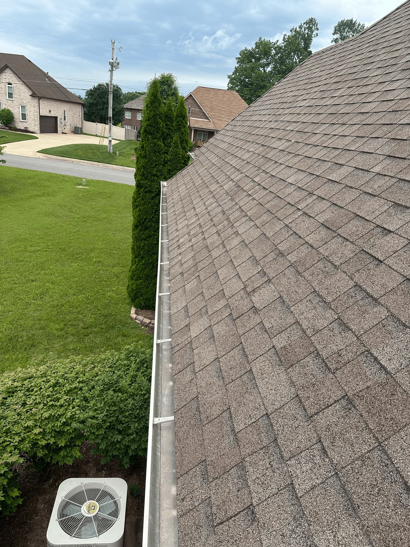 A cleaned asphalt roof and gutter line on a customer’s house