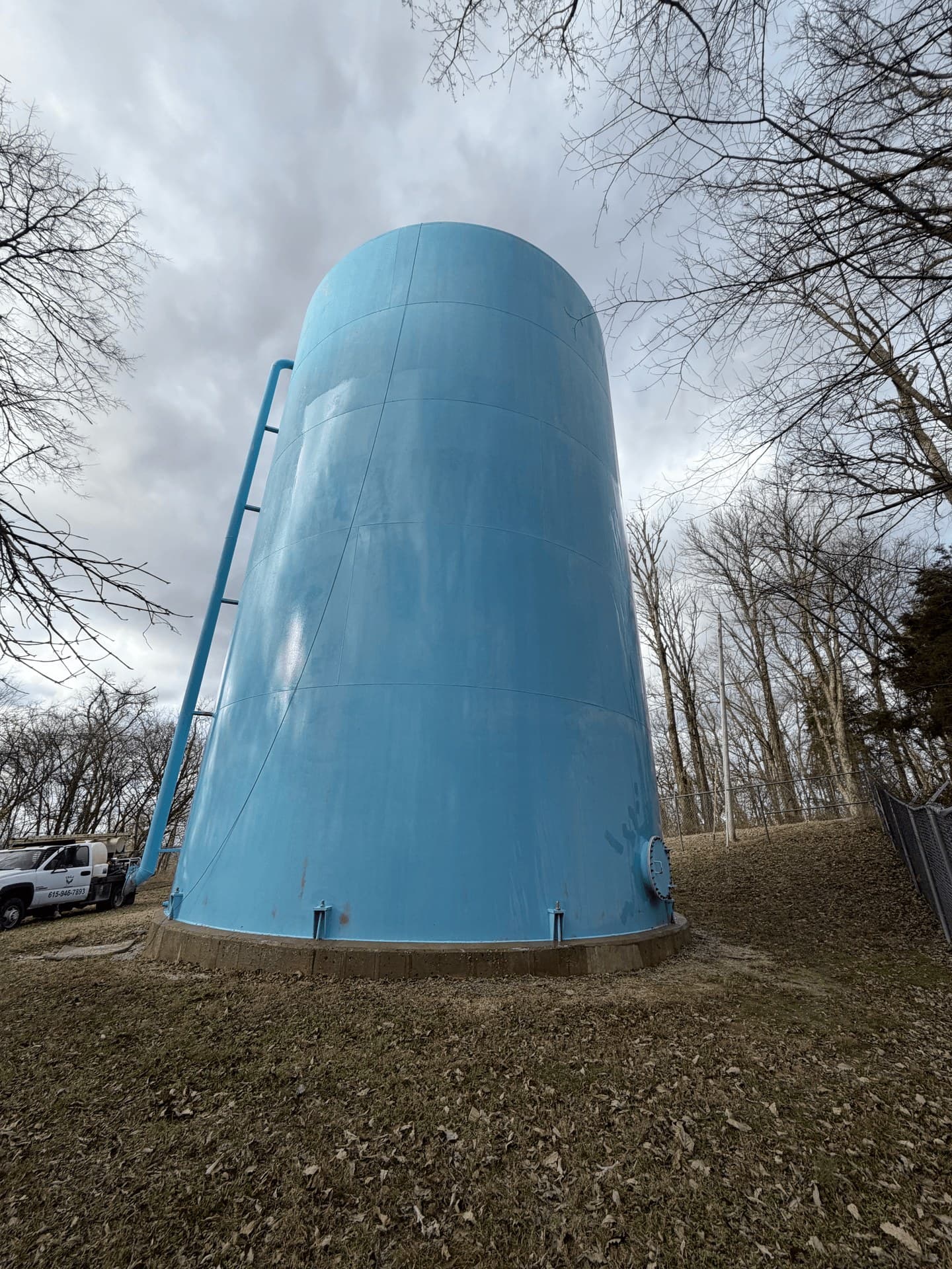 The same storage tank washed clean, blue paint showing again