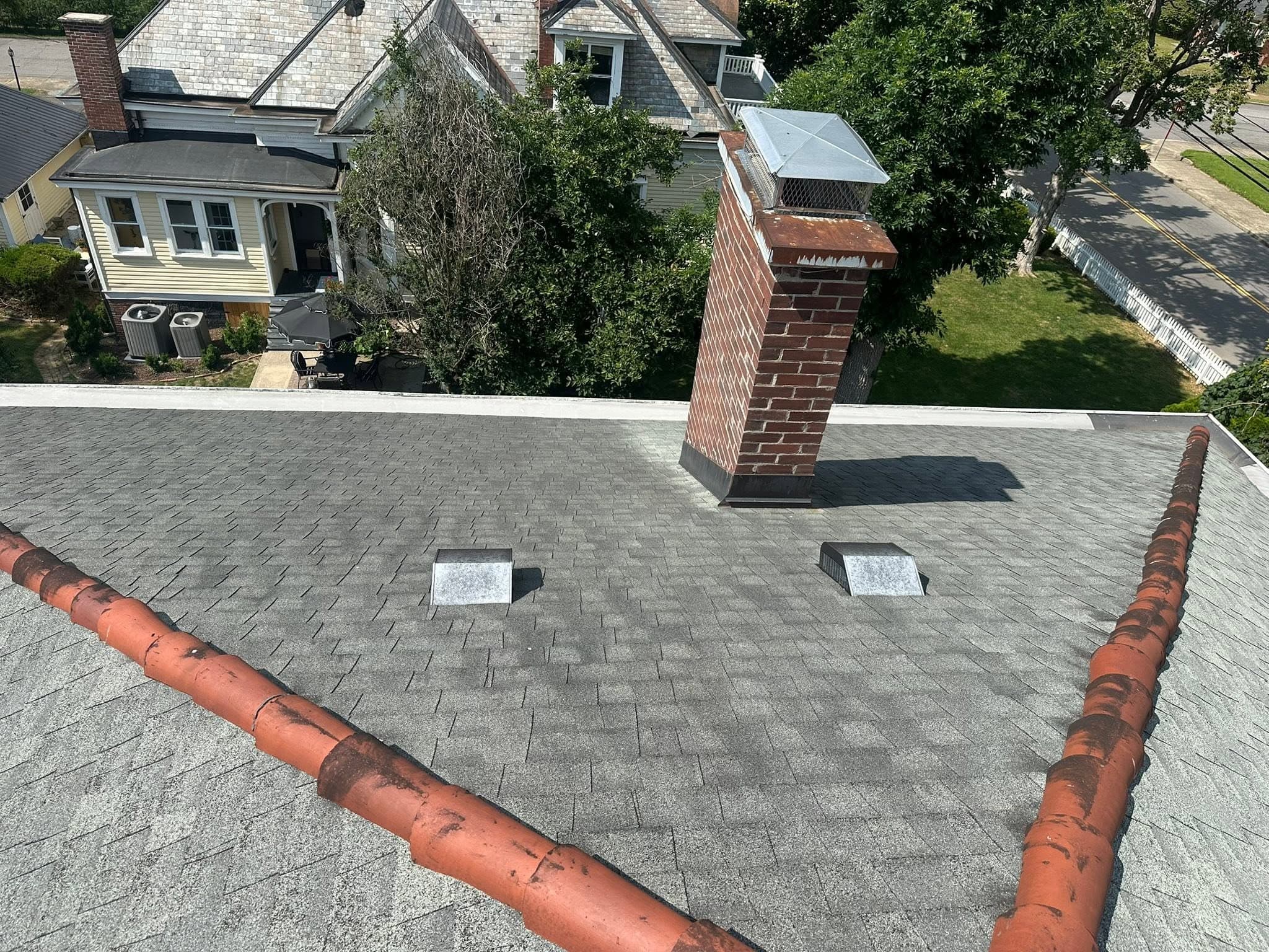 The same shingle roof and chimney after the roof wash
