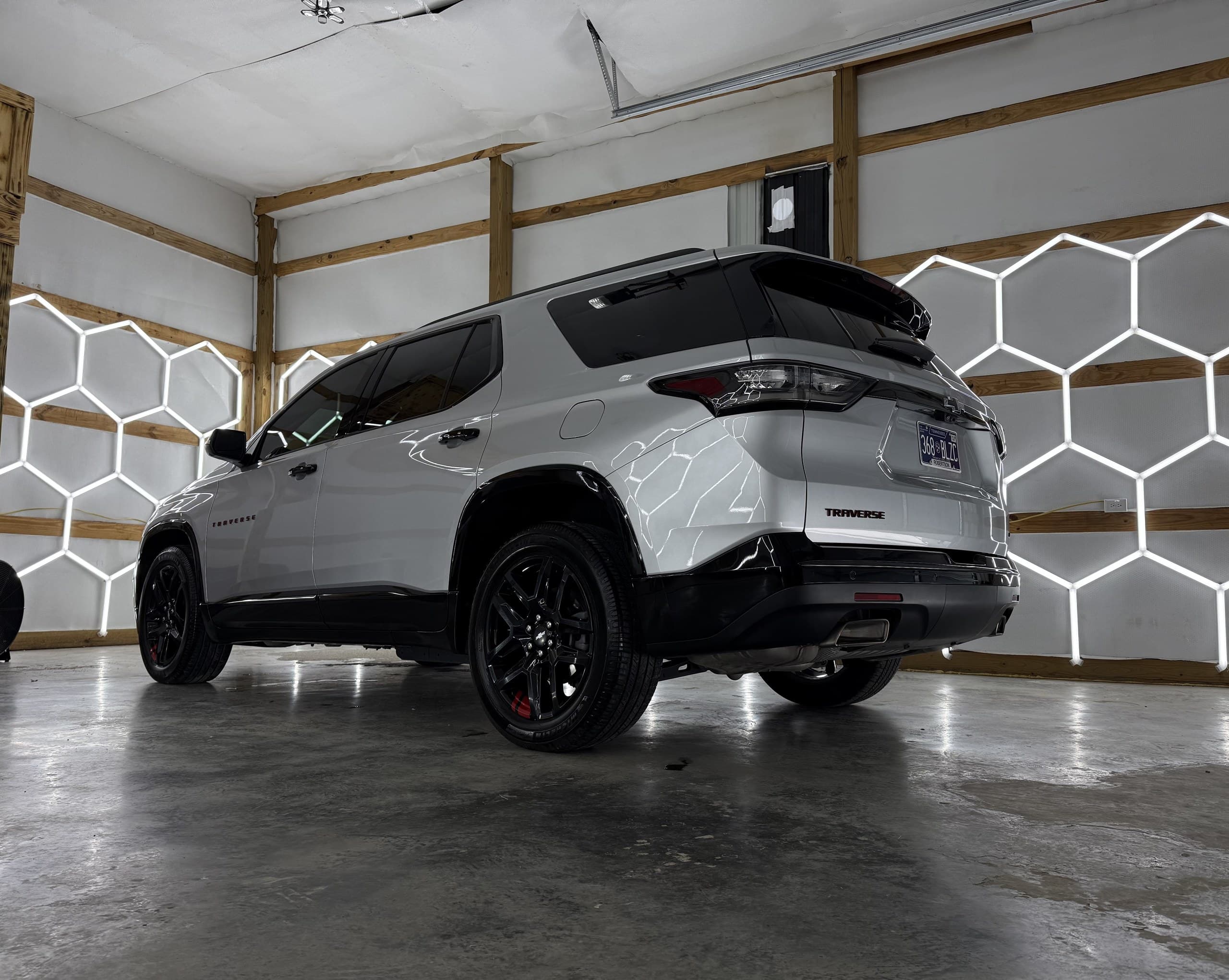 A white SUV photographed from the rear quarter after a full detail in the Eagle Pressure bay
